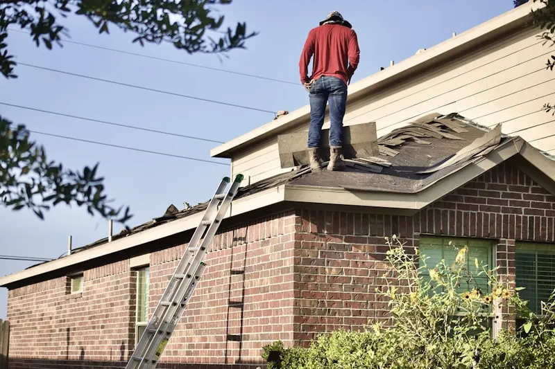 Professional roofer working on a residential roof in Flint